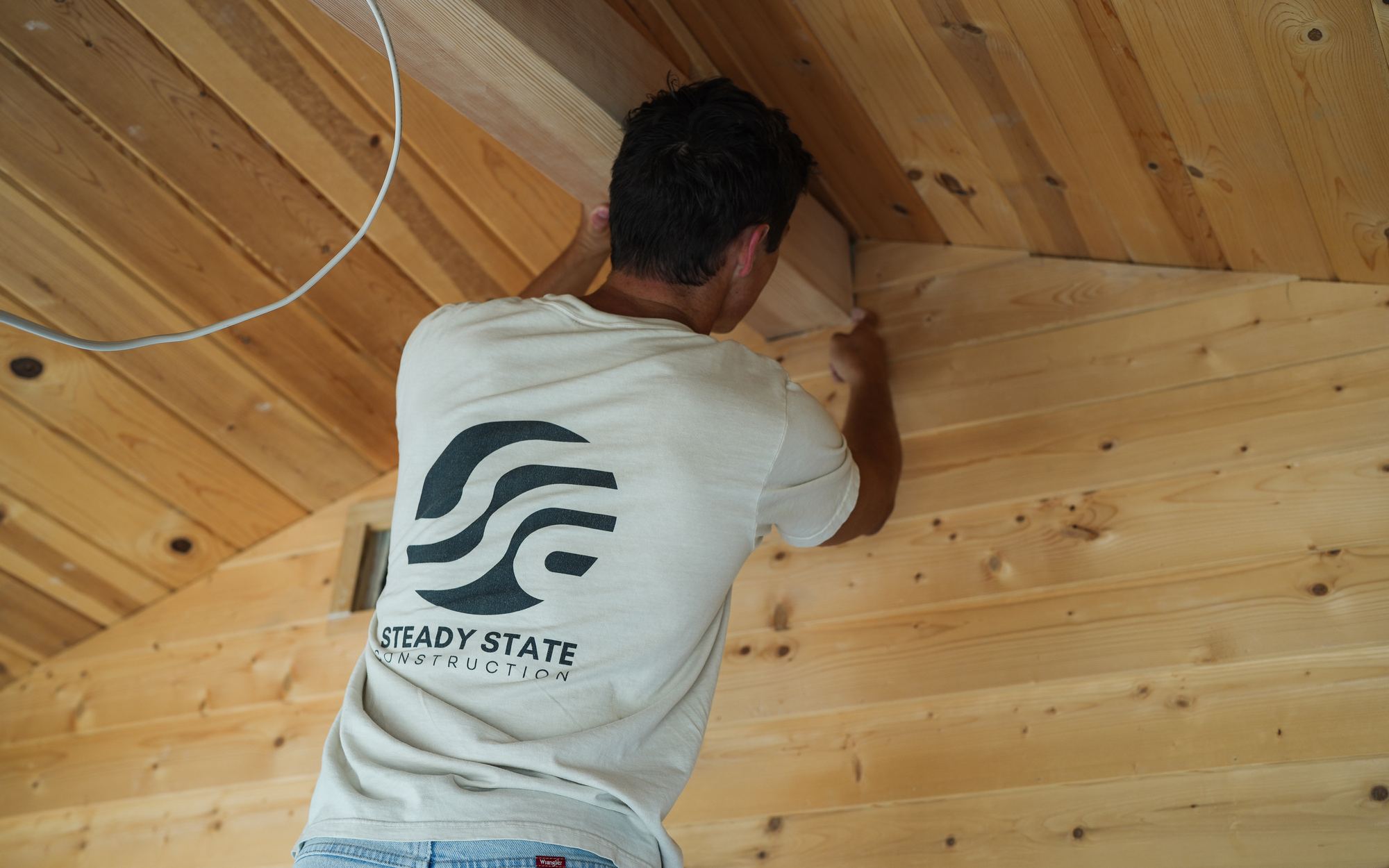 Fixing a beam overhead against a finished pine ceiling