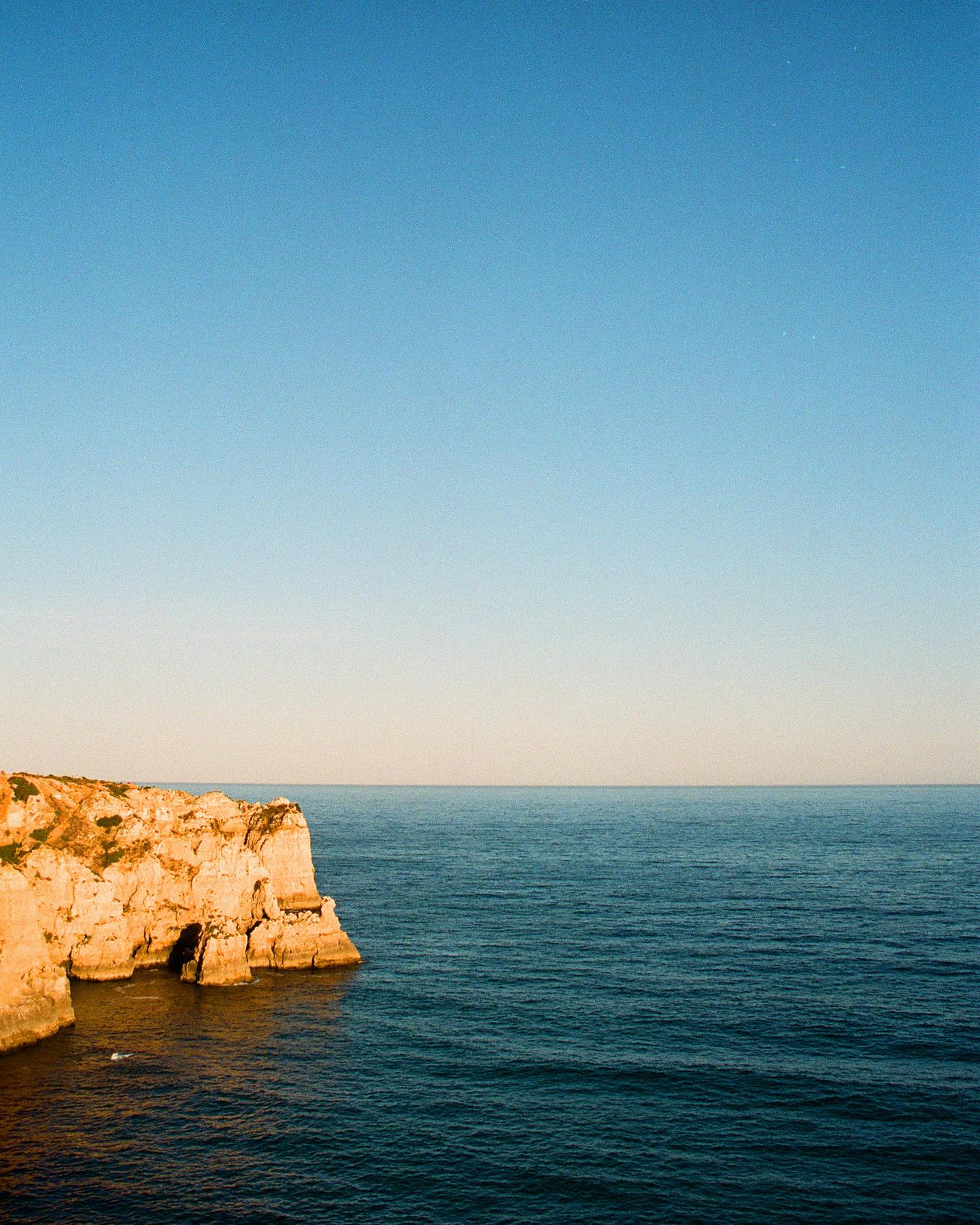 Sandstone cliffs meeting deep blue ocean